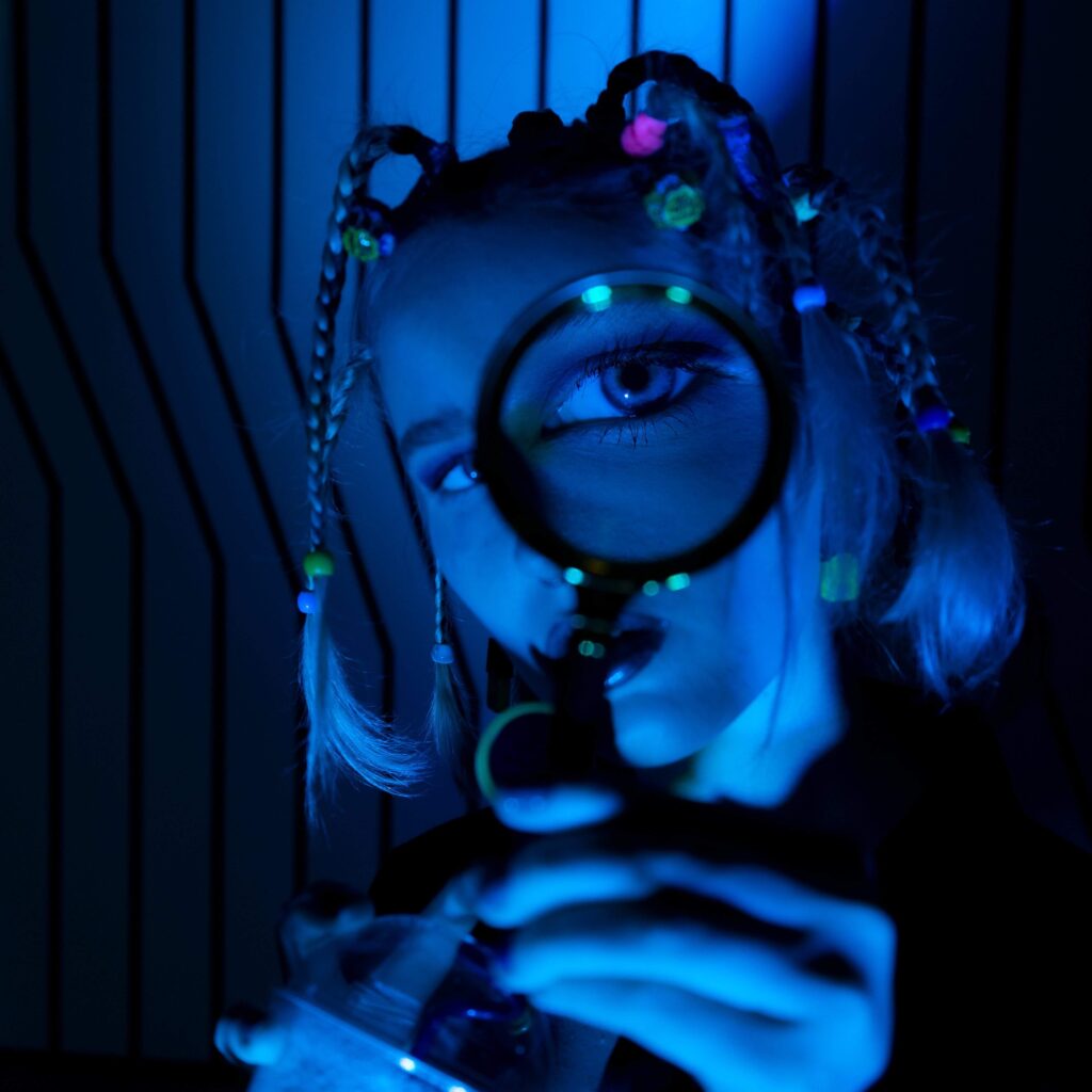 girl with magnifying glass looking at camera - CreatorTraffic.com