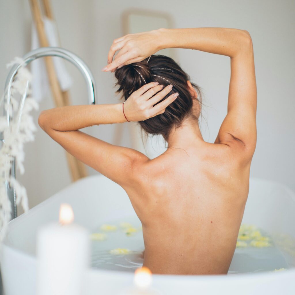 woman relaxing in bathtub shown from the back