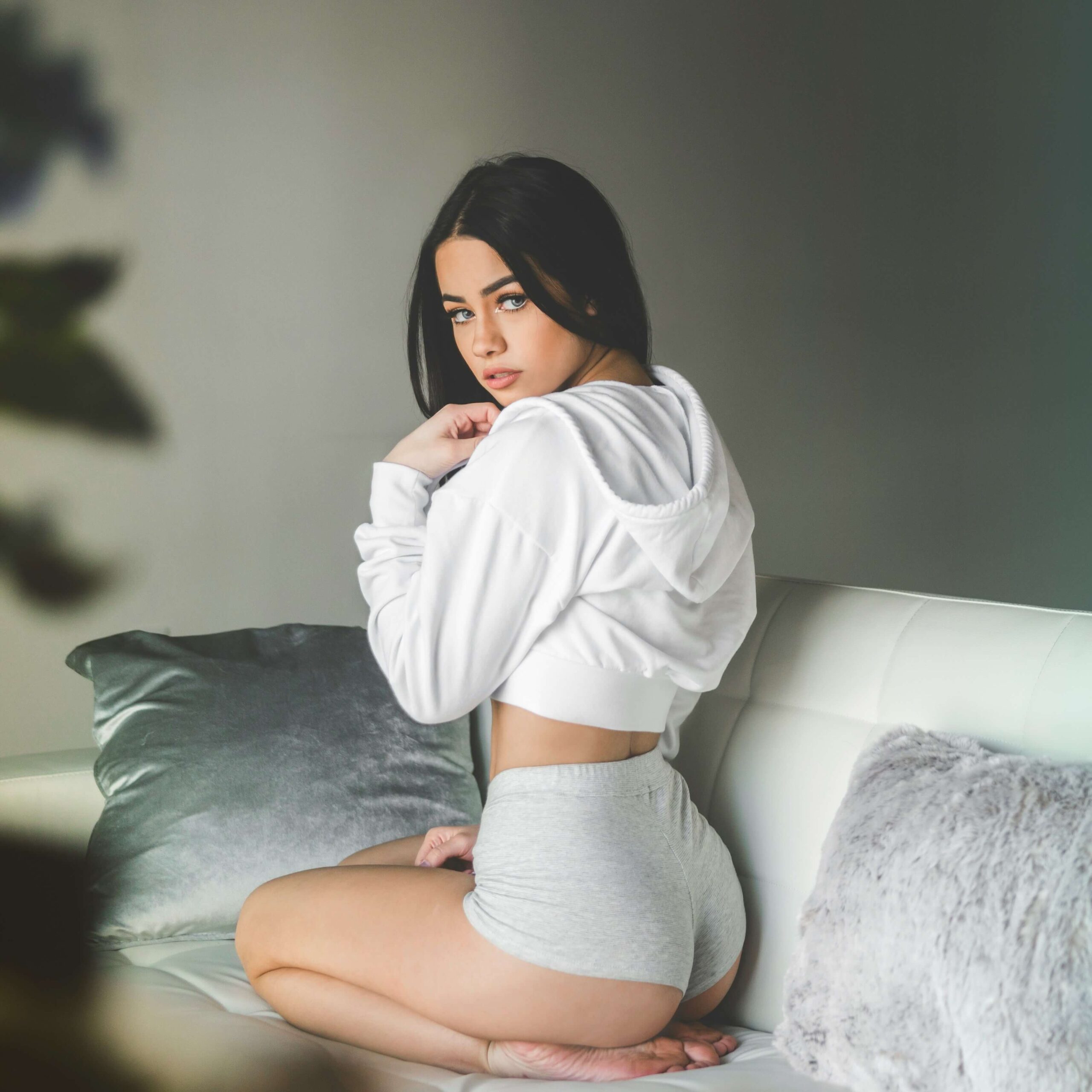 sexy brunette in hotpans sitting on sofa unsplash scaled - CreatorTraffic.com